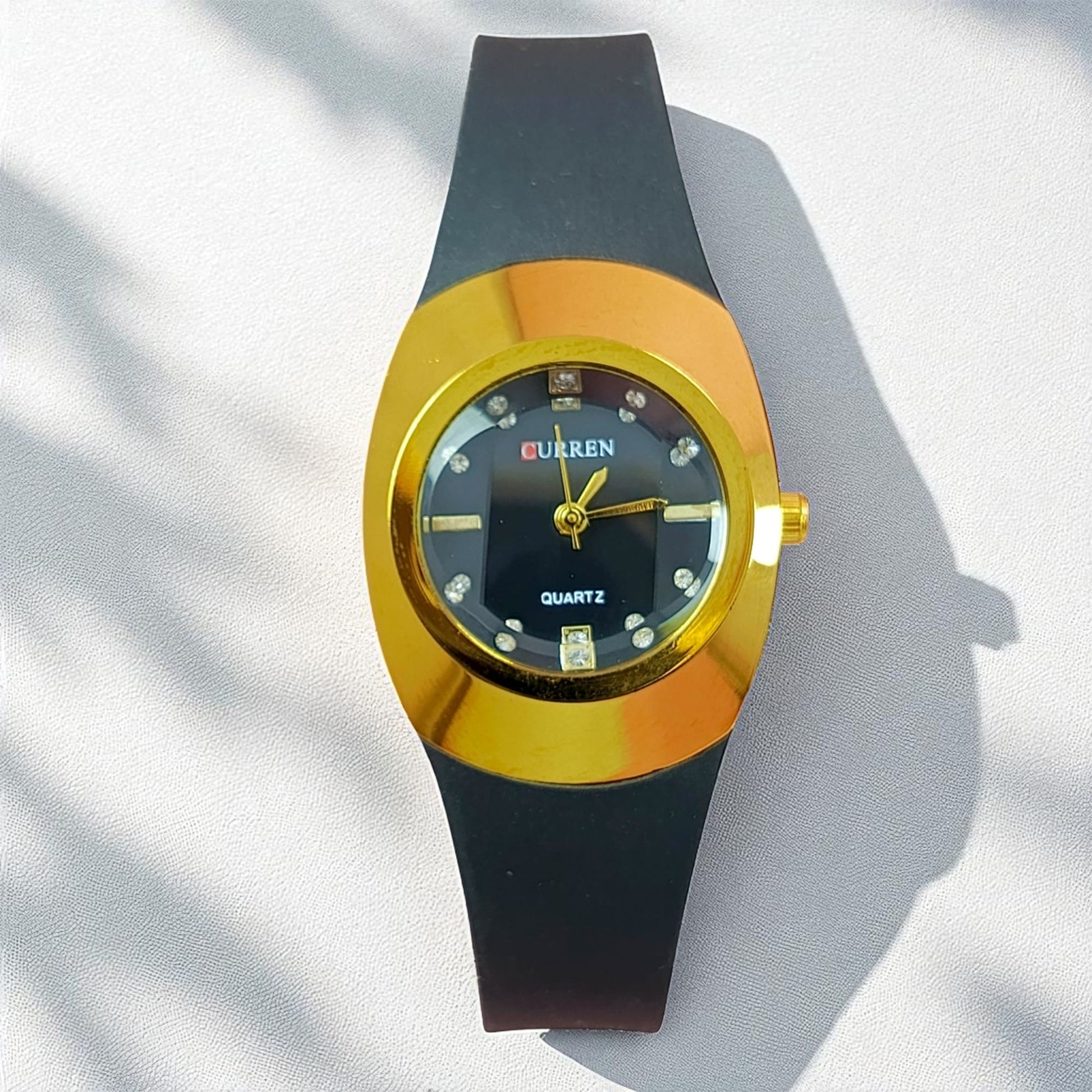 Gold & black ladies watch with oval dial and crystal markers on black strap