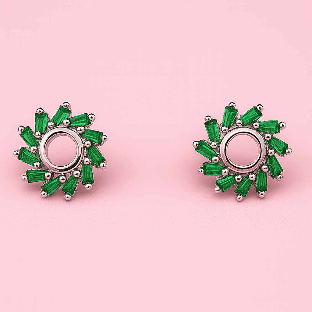 Pair of green halo stud earrings with emerald green stones arranged in circular design displayed on pink background