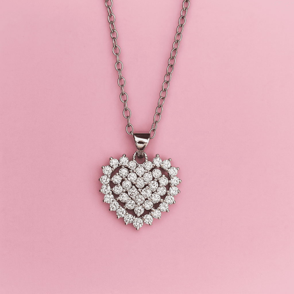 Close-up of elegant heart-shaped zircon pendant on silver chain displayed on pink background