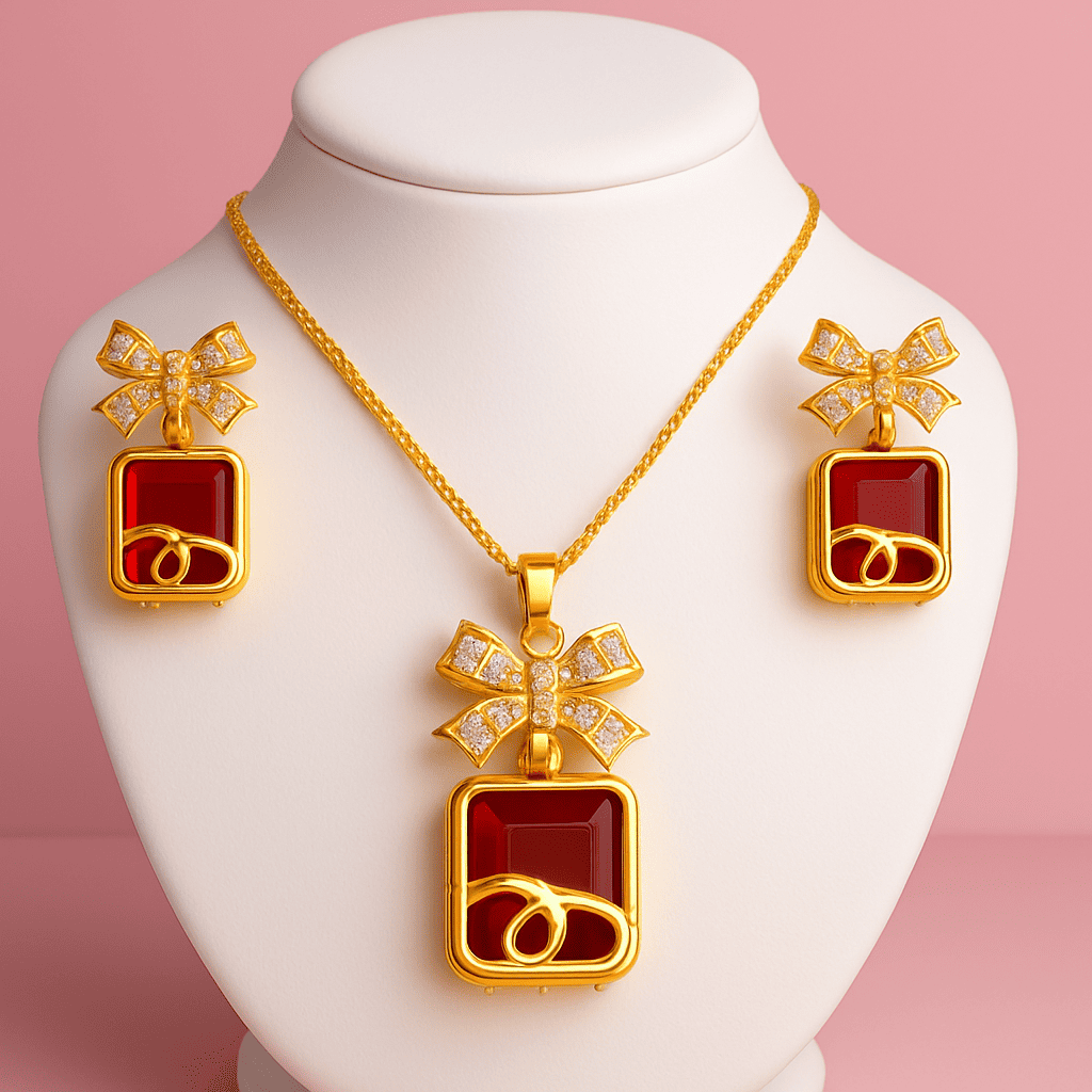 Gold bow pendant necklace and earrings set with red gemstones on white bust with pink background